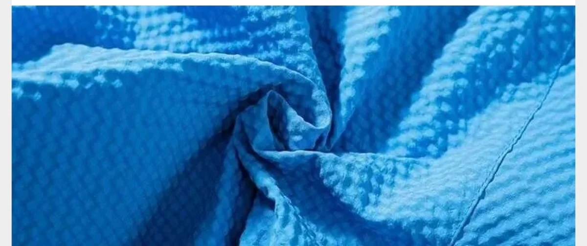 Close-up of blue puckered fabric gathered into soft folds